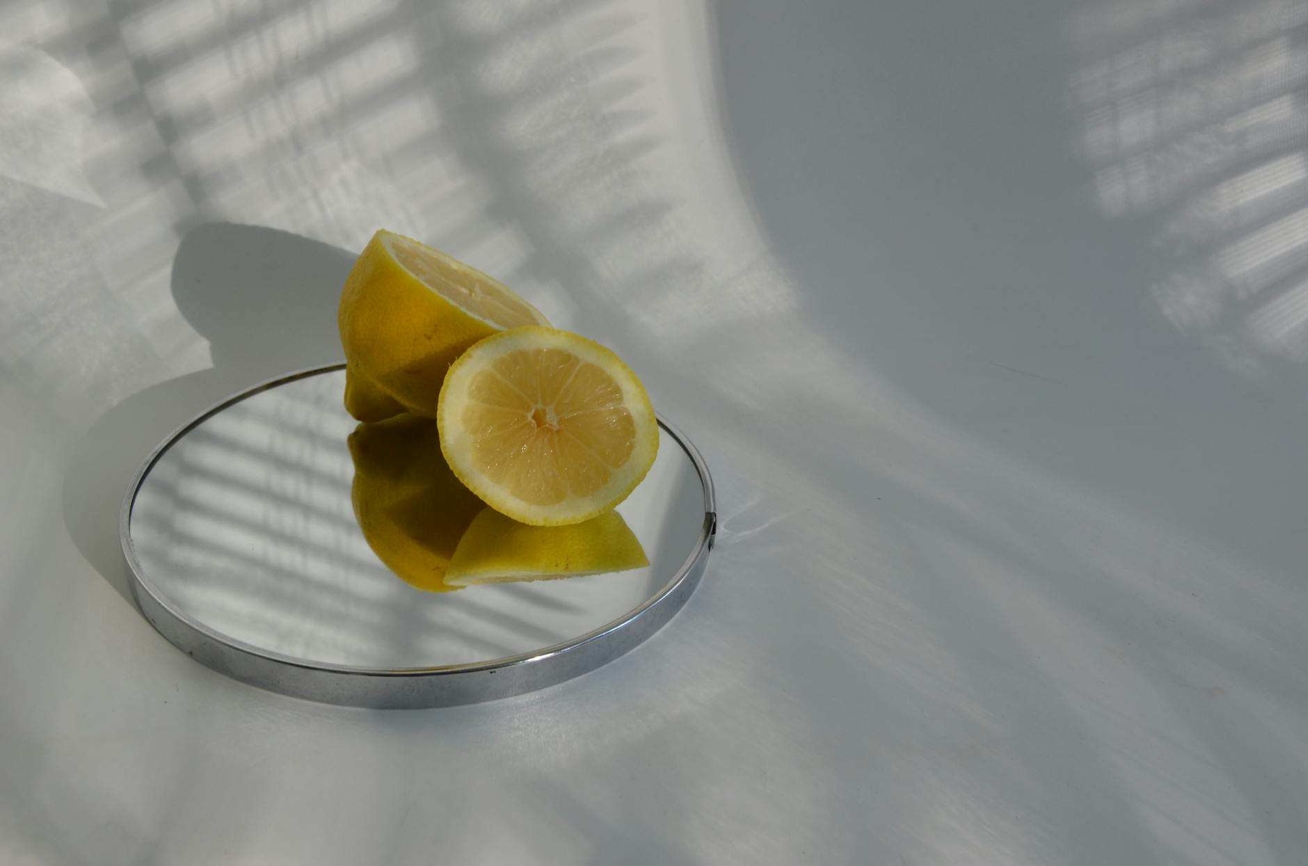 Sliced lemons on a reflective surface, symbolizing sensory stimulation and freshness.
