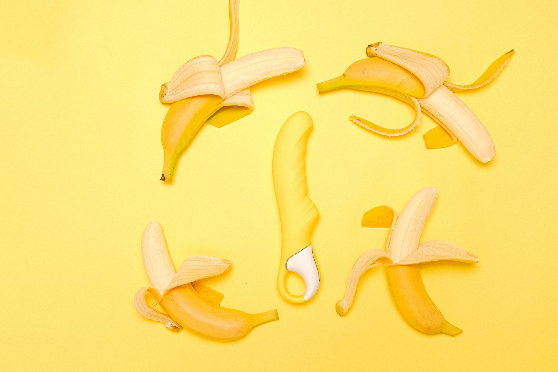 Gelber Lemon Vibrator auf gelbem Hintergrund mit frischen Zitronen
