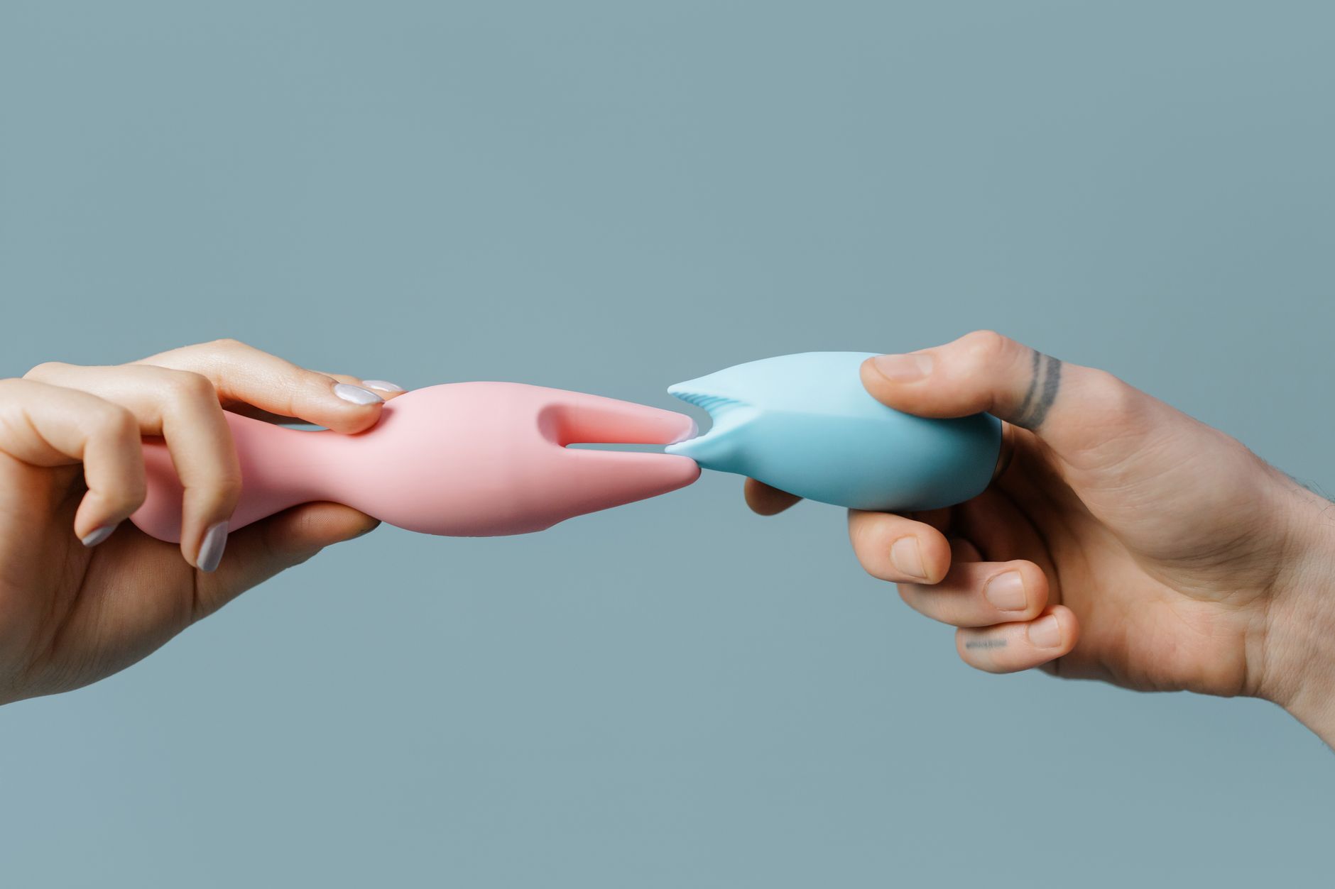 Woman holding colorful vibrators against a purple background