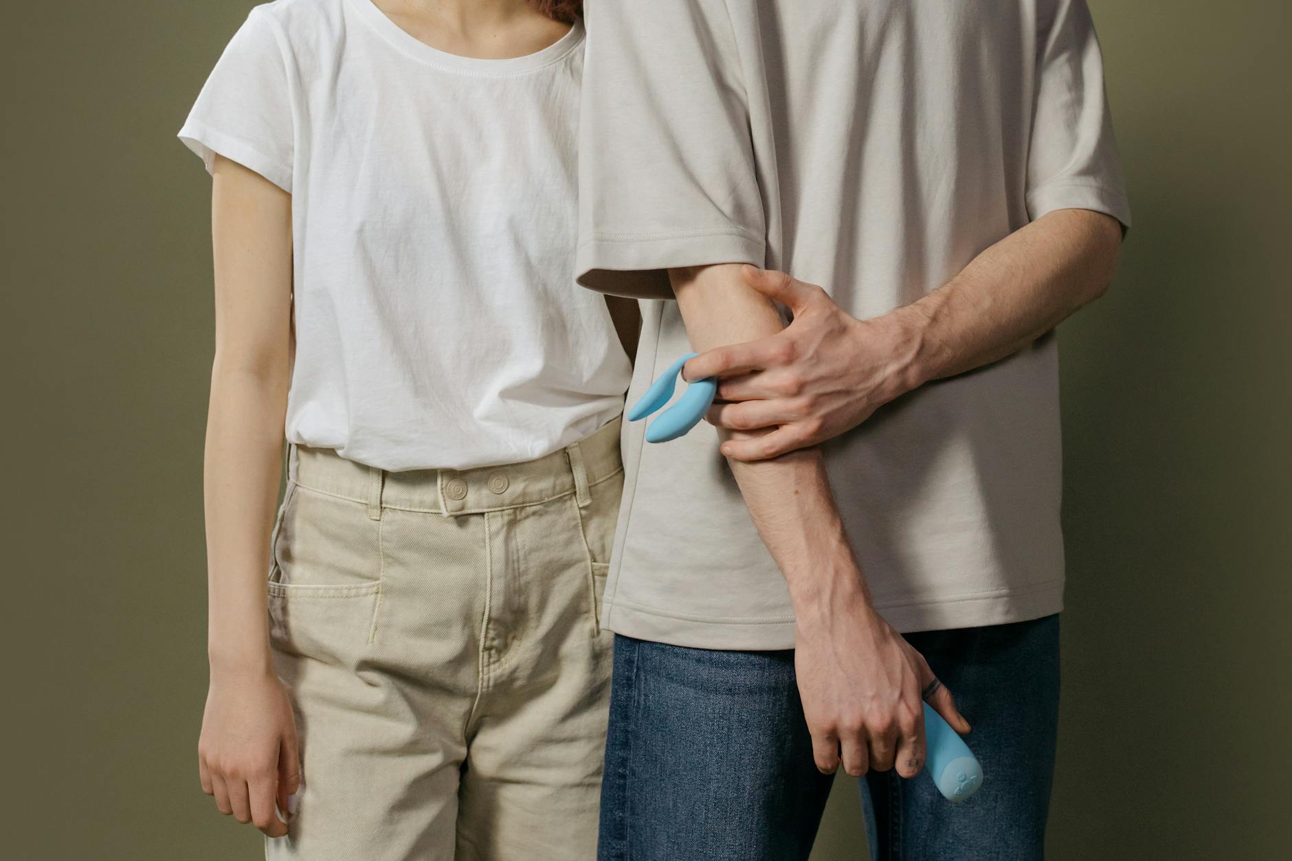 Frau hält einen rosa Lemon Vibrator in der Hand, mit Kunstbüchern im Hintergrund, das symbolisiert intime Selbstfürsorge